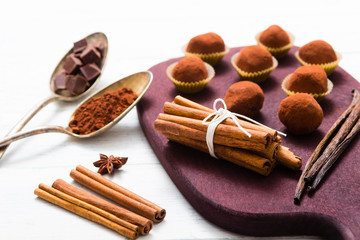 chocolate truffles, cocoa powder, broken dark chocolate on white wooden