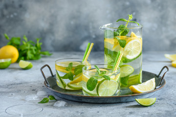 Fresh cool lemon lime mint water in glasses on a tray. Detox, healthy food, fitness cocktail. Selective focus