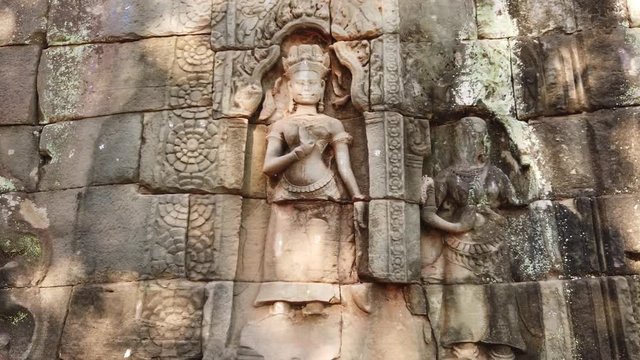 Divine dancer Apsara carved on a stone wall at the entrance of the temple TA Prom in Angkor Wat Cambodia. 