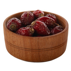 heap of dried hips in wooden cup isolated on white background