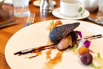 Fancy plate of duck breast on white plate in high end restaurant
