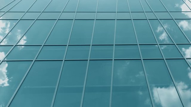 Modern glass facade windows reflect flying airplane and clouds, time lapse shot on Red camera