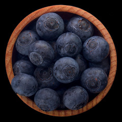 heap of blueberry in wooden cup isolated on black background. top view