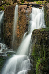 Fototapeta na wymiar mossy boulders of waterfall. summer nature background.