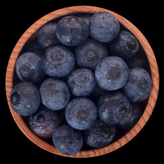 heap of blueberry in wooden cup isolated on black background. top view