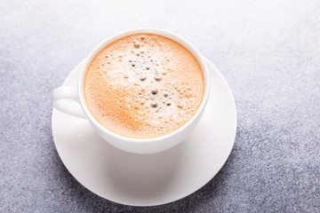 Cup of coffee on stone background. Office workplace. Top view. Copy space