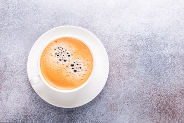 Cup of coffee on stone background. Office workplace. Top view. Copy space