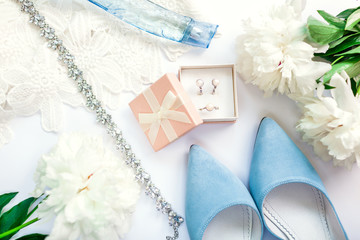 Stylish female wedding clothes, blue shoes and accessories with flowers. Morning of bride