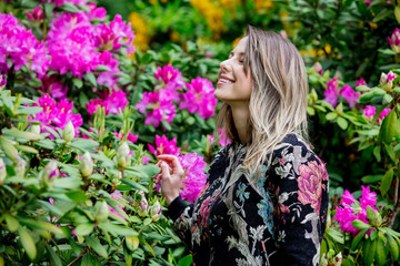 Naklejka premium style woman near rhododendron flowers in a grarden in spring time