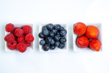 Frische Beeren in Schalen auf weißem Hintergrund