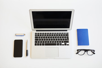 High angle view of business items such diary, pen and eyeglasses and modern portable devices on white table