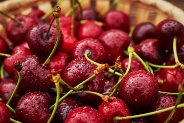 cherries in bowl and near on wooden background