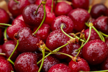 cherries in bowl and near on wooden background