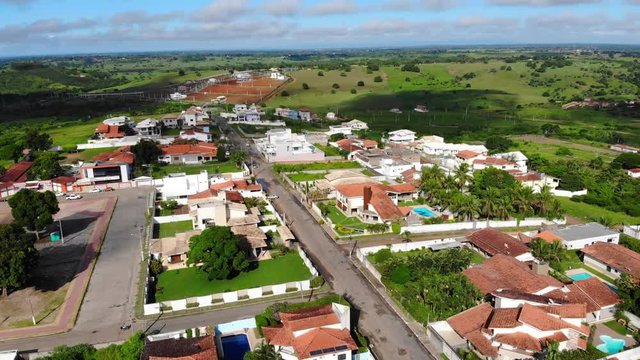 Panoramic Aerial drone view of Cruz das Almas, Bahia, Brazil. Show houses, small buildings in the neighborhood, and green environnement.  