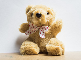 Soft toy fluffy bear sitting on a wooden board