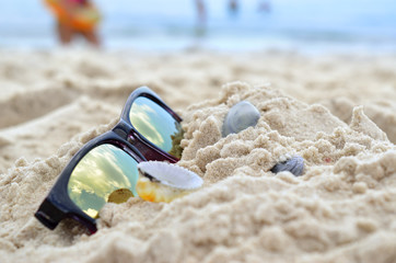Clouds reflected in sunglasses on the beach