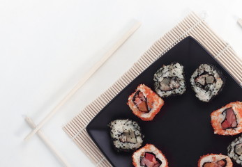 different types of Maki sushi on a black plate