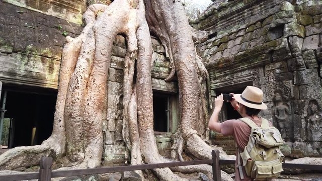 the tourist considers the bas-reliefs of the temple TA Prom Angkor Wat (Siem reap, Cambodia) slow motion