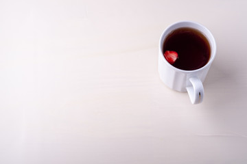 Copy space hot cup of tea with strawberry fruit isolated on white background