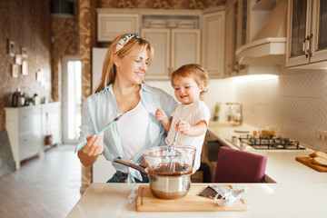 Mother with her daughter mixing melted chocolate
