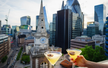 Fruit cocktails on the foreground and blurry aerial view of skyscrapers of the world famous bank...