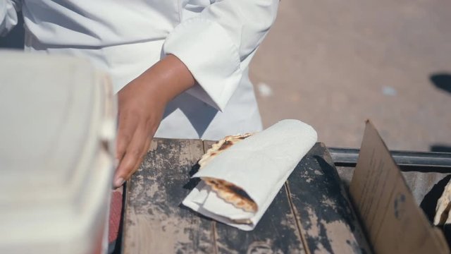 Typical Argentinian food being cooked, prepared and handed to a client.