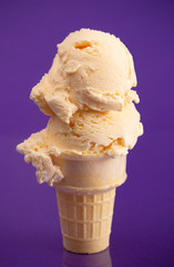 A Double Scoop Vanilla Ice Cream Cone on a Purple Background