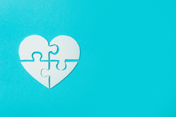 White heart made of symbolic autism puzzle pieces