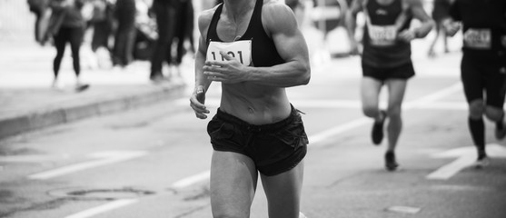 Unrecognizable muscular runner outdoors. Long distance running. Black and white.