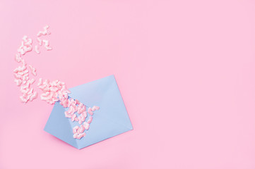 Small pink hearts with envelope, on pink background with copy space