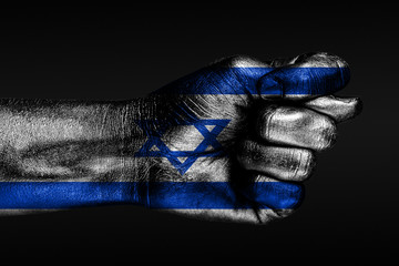 A hand with a painted Israel flag shows a fig, a sign of aggression, disagreement, a dispute on a dark background.