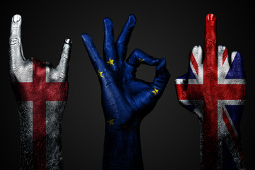 a set of three hands with a painted flag of England, United Kingdom and European Union show middle finger, goat and Okay, a sign of aggression, protest and approval on a dark background.