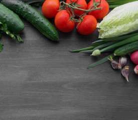 Fresh summer vegetables on a black wooden table