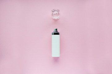 bottle of perfume with the lid open on a pink background. soft focus. copy space. isolated.