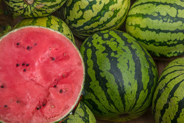 Many big sweet green watermelons and one cut watermelon.Young green watermelon.