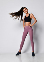 Slim brunette fitness woman runner sprinter before workout exercise in purple sport wear full body