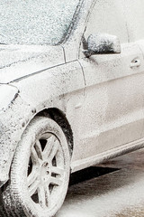 Car wash with foam in car wash station. Carwash. Washing machine at the station. Car washing...