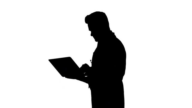 Silhouette Man wearing white medical coat and stethoscope walking with laptop.