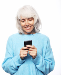 Lifestyle, tehnology and people concept: old woman wearing casual talking on cell phone over white background