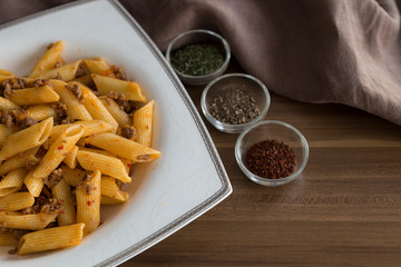 The pasta with spices on the wooden background for food photography concept.