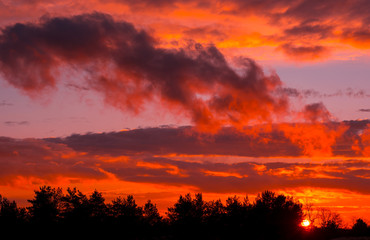 Fototapeta na wymiar Fiery orange sunset colorful and speckled clouds.