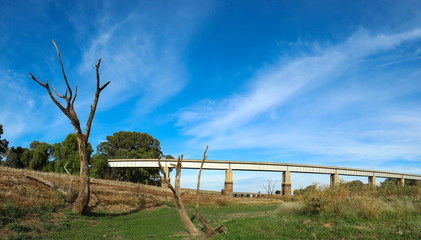 Panoramic view of disused Railway Bridge over Joyces Creek its entry to Lake Cairn Curran on the Moolort Plains near Newstead, Victoria, Australia