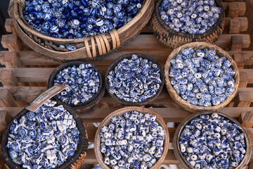 woven baskets full of blue and white beads for sale at the marketplace