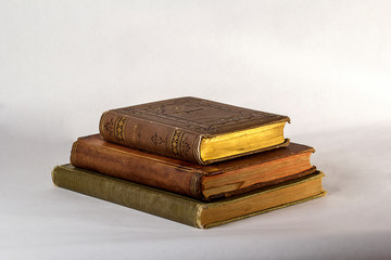Stack of Three Antique books on a white background.