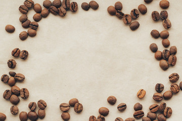 Fried coffee beans on paper background. Top view with copy space.
