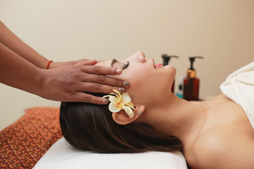 Obraz na płótnie Canvas Young asian woman receiving head massage at beauty spa.