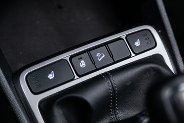 Сlose-up of the car  black interior:  dashboard, seat and steerling wheel heating buttons, off...