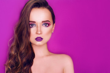 Fashion model woman creative pink and blue make up.  Beauty art portrait of beautiful girl with colorful abstract makeup. Beautiful Eyes Glitter . Purple bright lips, long cerly hair. Pink background