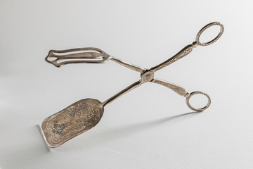 silver cake tongs on white