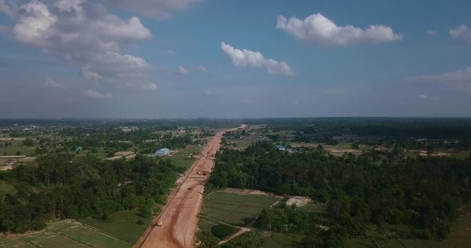 flying above bilding road between forest in field with opening horizon and panorama
